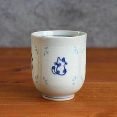 a small cup sitting on top of a wooden table