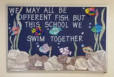 a bulletin board with fish on it in a school gym area that reads, we may all be different fish but in this school we swim together