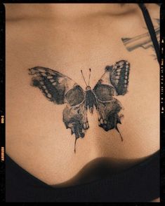 a woman's stomach with a butterfly tattoo on it