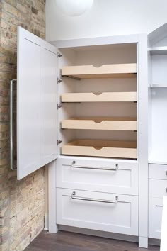 an empty pantry with white cabinets and drawers