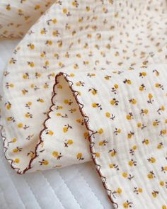 a white quilt with yellow flowers on it