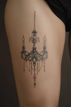 a woman's thigh with a chandelier tattoo on it