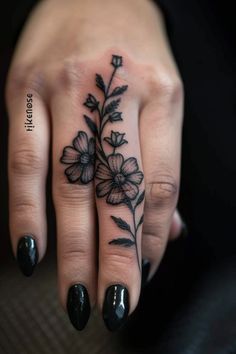 a woman's hand with a flower tattoo on it