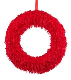 a red wreath hanging on a white wall