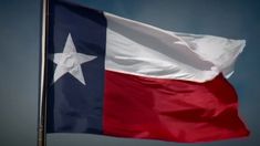 the texas flag is flying high in the sky