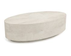 an oval concrete coffee table sitting on top of a white floor