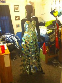 a mannequin dressed in a dress made out of plastic bottle caps and other items