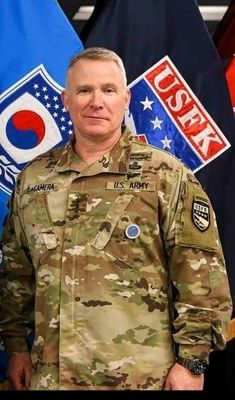 a man in uniform standing next to flags