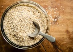 a jar filled with oatmeal next to a spoon on top of a wooden table