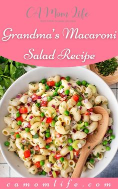 a white bowl filled with pasta and peas on top of a pink table cloth next to a wooden spoon