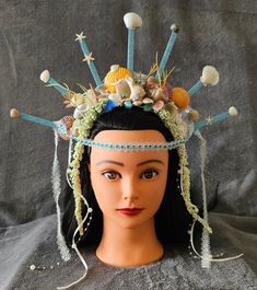 Unlock your true Mythical Sea Goddess This one-of-a-kind gorgeous glistening Mermaid headpiece has been handcrafted with real seashells, rhinestones, silk flowers, sea glass, satin ribbon, faux pearls glitter, zip ties for stability and a whole lot of love.   Adorned on top of a satin headband with additional support strap for easy all day and night wear.  Complete with fairy lights to illuminate you into the evening and glimmer through your festival, prom, parade, carnival, Mardi Gras, Halloween, burning man, cosplay, or any other special event that you are sure to be the standout head turner. Crowns are intended for adult use only.  Not recommended for children. Thank you so much for stopping by my Etsy!  If you're lovin' this headpiece/crown but envision a different color and/or would l Mermaid Headpiece, Crown Light, Sea Goddess, Man Cosplay, Mermaid Crown, Satin Headband, Night Wear, Zip Ties, Costume Hats