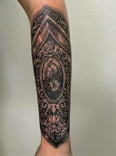 a man's arm with an ornate frame and flowers on the inside of it