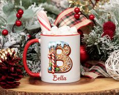 a red and white coffee mug filled with marshmallows on top of a wooden table