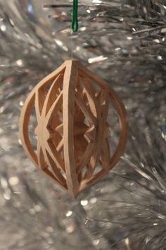 a wooden ornament hanging from the top of a christmas tree with silver tinsel