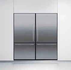 two stainless steel refrigerators sitting side by side in an empty room with white walls