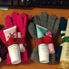 three gloves and two tubes are sitting on a desk next to a keyboard with christmas items wrapped around them