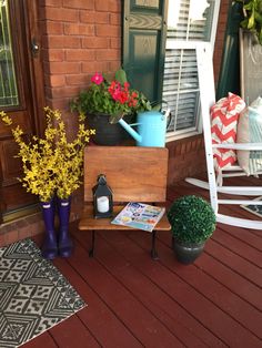 the porch is decorated with colorful flowers and potted plants