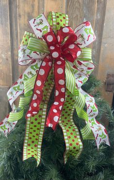 a christmas tree decorated with green and red ribbons, bows and polka dot bow on top