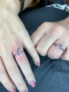 two people with matching tattoos on their fingers