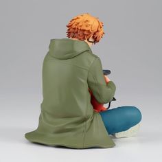 an anime figurine sitting on the ground with his head turned to look like he is