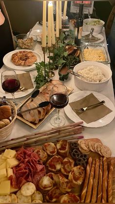 a table filled with different types of food and wine glasses on top of each other