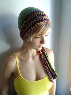 a woman wearing a yellow tank top and a multicolored crocheted hat