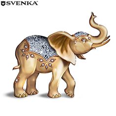 an elephant figurine in gold and silver with jewels on its back, standing upright