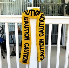 a yellow scarf that says caution on it