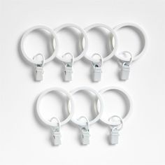 six white rings with handles on each side and two hooks attached to the back of them