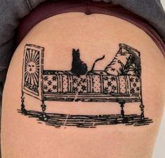 a woman's thigh with a cat sitting on top of a couch tattoo design