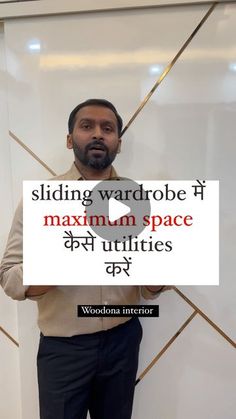 a man standing in front of a white wall holding a sign that reads sliding wardrobe maximum space