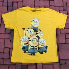 Heavy Cotton Yellow T-Shirt Featuring Minions Size Adult M 100% Heavy Cotton Armpit To Armpit 19" Shoulder To Hem 24" Double Stitched Seams, Bias Covered Seam At Collar Nwot, New, Never Worn Smoke Free Pet Free Environment Yellow Crew Neck T-shirt With Cartoon Print, Yellow T-shirt With Character Print, Yellow Graphic Tee With Character Print, Fun Yellow Crew Neck Shirt, Yellow Short Sleeve Top With Character Print, Yellow Graphic Tee With Crew Neck, Yellow Cartoon Print T-shirt For Summer, Fun Yellow Tops With Character Print, Yellow Graphic Tee Short Sleeve T-shirt