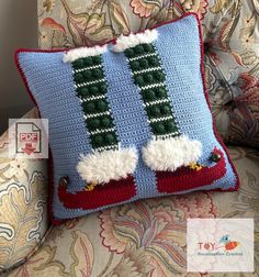 a crocheted christmas stocking pillow sitting on top of a couch next to a chair