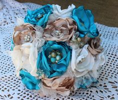 a bridal bouquet with blue and white flowers on a lace doily tablecloth