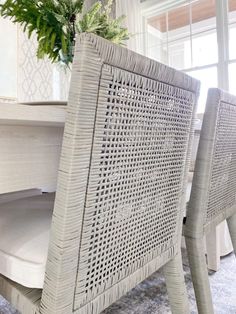 a close up of a table with chairs and a potted plant in the background