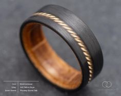 a black and gold wedding ring with rope inlays on the inside of it