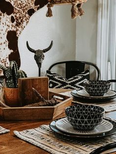 the table is set with dishes and utensils, including a cow skull head