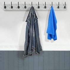 a coat rack with two coats hanging from it's hooks and three blue towels