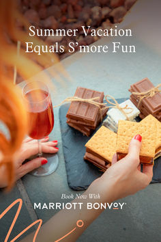 a woman holding a glass of wine next to some cookies and waffles on a table