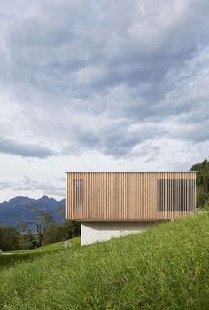 a wooden structure sitting on top of a lush green hillside