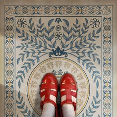 a pair of red shoes sitting on top of a tiled floor