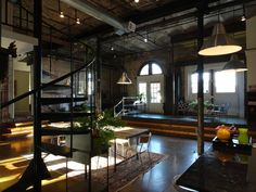 the interior of an industrial building with stairs leading up to two floors and tables on either side