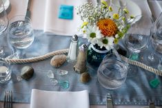 the table is set with silverware and flowers