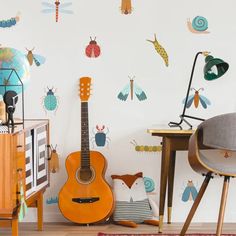 a room with a guitar on the floor next to a table and chair in front of it