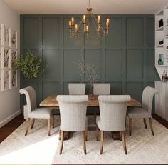 a dining room with green walls and white chairs