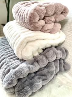 towels stacked on top of each other in various colors and sizes, all folded up