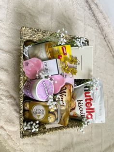 a basket filled with lots of different types of snacks and condiments on top of a bed