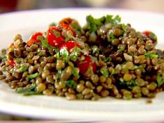 a white plate topped with lentils and tomatoes