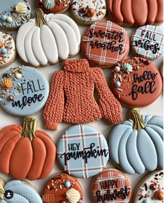 some decorated cookies with words on them and pumpkins in the background, one for each cookie