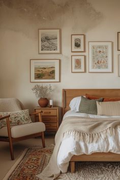 a bed sitting in a bedroom next to a chair and pictures on the wall above it